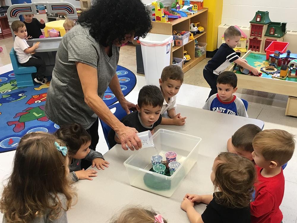 Teacher leading hands-on activity with preschool children
