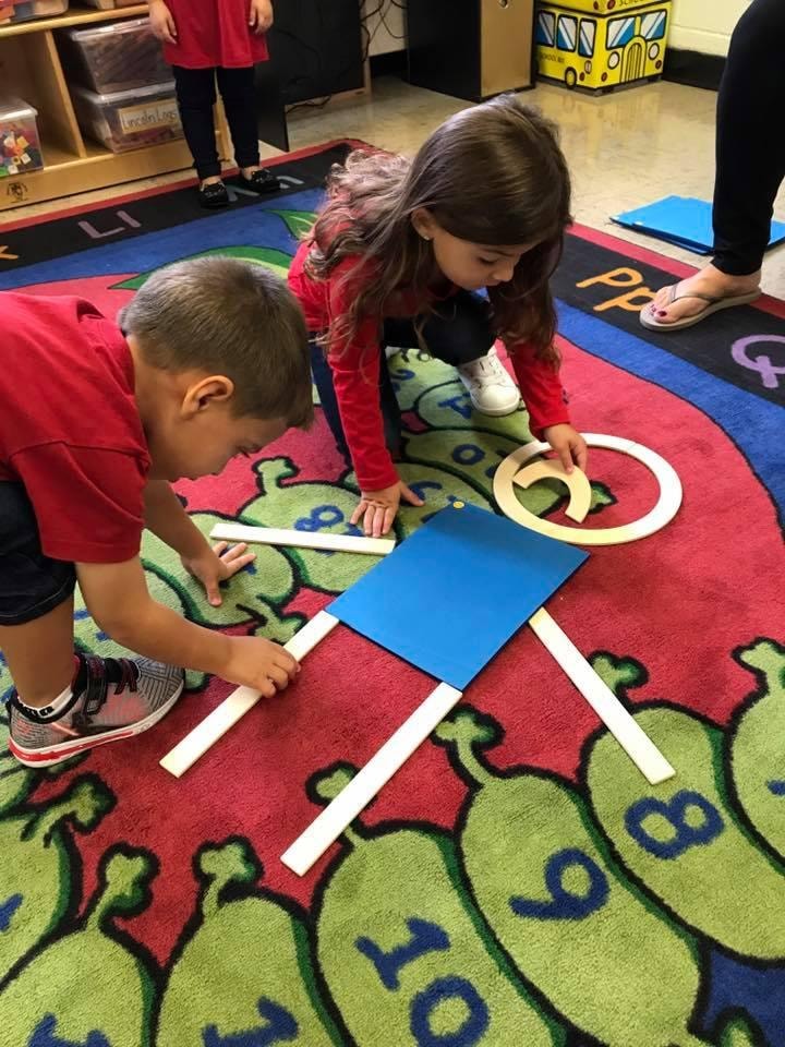 Children learning shapes on classroom floor