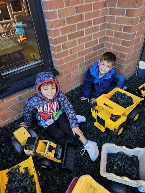 Two children playing with toy construction vehicles