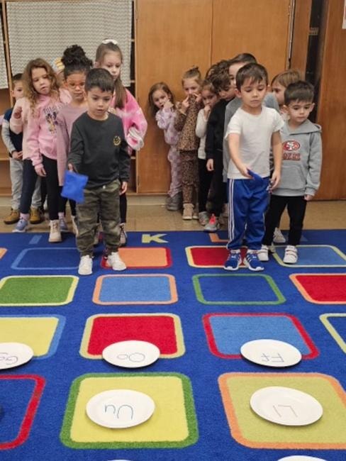 Group of children standing on colorful classroom rug